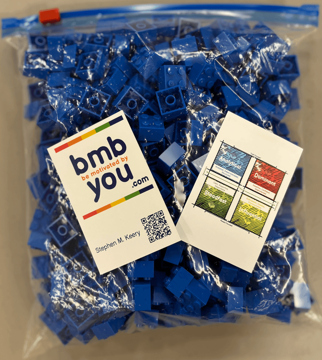 Clear plastic bag filled with blue Lego bricks, featuring labels and a QR code.