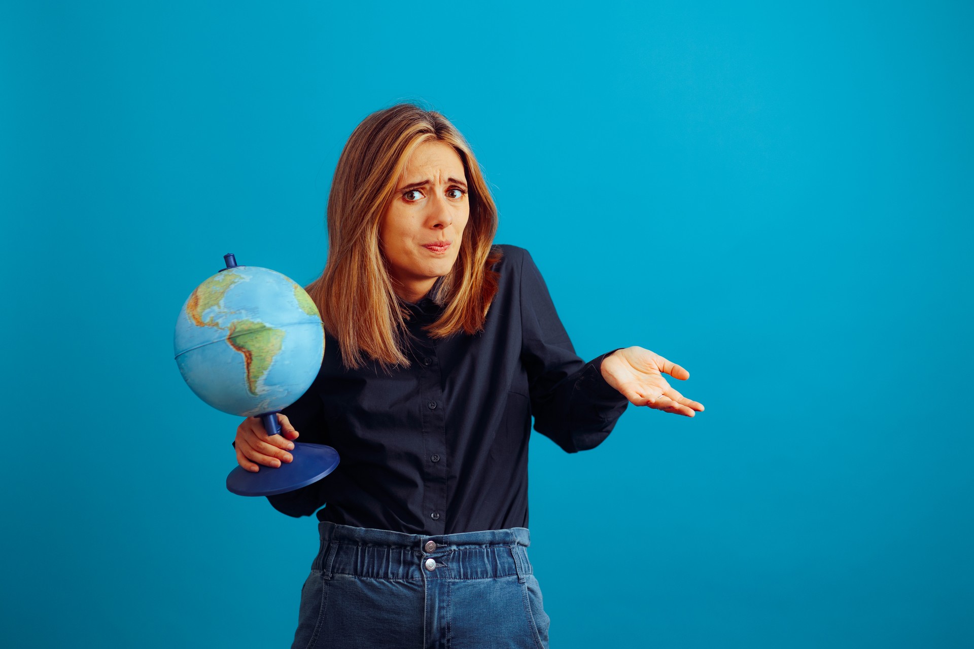 Woman Holding a Globe Wondering Where to Travel Next